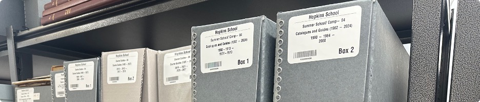Hopkins School archival boxes on shelves with descriptive labels, box numbers, and barcodes.